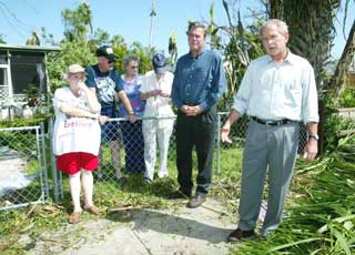 U.S. President George W. Bush (R) tours Florida damage from Hurricane Charley with Florida's Governor Jeb Bush (2nd R) in Punta Gorda, Florida, August 15, 2004. Bush Sunday assured Floridians help was on the way to ease their suffering after a devastating hurricane, as he toured the wreckage of a state critical to his re-election.