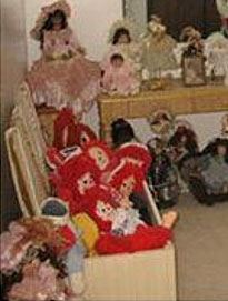 A collection of other dark haired dolls look grimly onto the  massacred Raggedy Ann bodies stuffed into a trunk. Perhaps the dark ones are the ring leaders who pass judgment on the redheads condemning them to internment. 